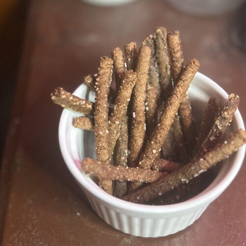 Pumpernickel pretzel sticks in a cup for snack.