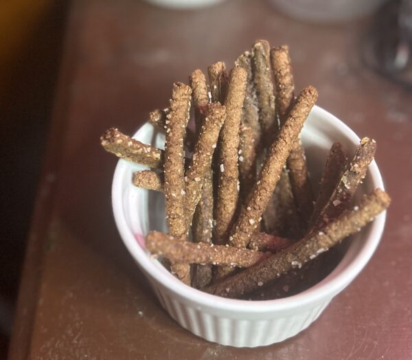 Pumpernickel pretzel sticks in a cup for snack.