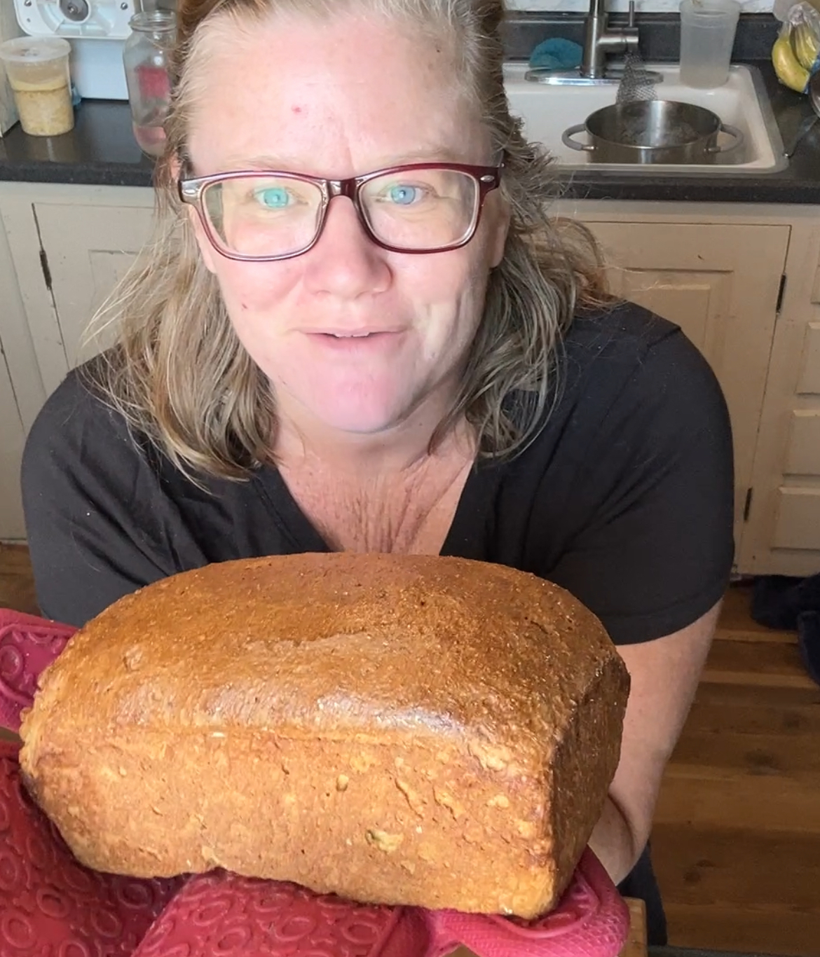 Dr. Mel holding a loaf of freshly baked, fresh milled superbly soft sandwich bread.